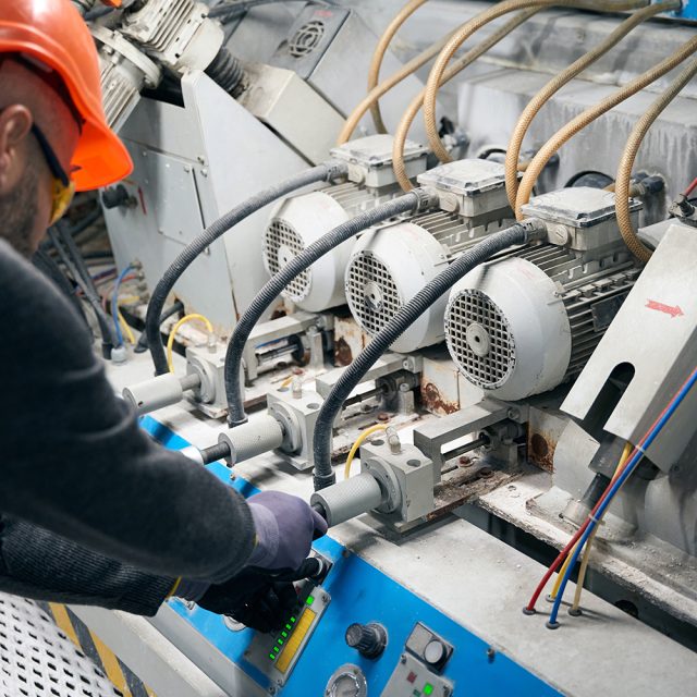 Employee works with a device for blowing argon into a double-glazed window, a man wearing protective gloves and safety glasses