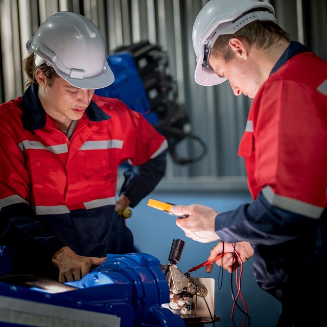 male engineer workers maintenance automatic robotic arm machine in a factory. worker checking and repairing automatic robot hand machine. technician worker check for repair factory machine.