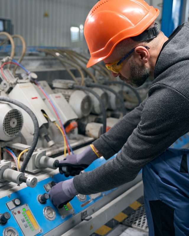 Master works with a device for blowing argon into a double-glazed window, a man wearing protective gloves and safety glasses