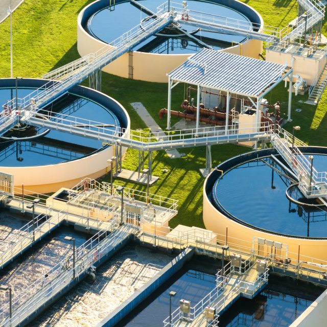 Large-scale industrial water treatment plant purifying and recycling water through filtration and chemical processes to meet health and safety standards.